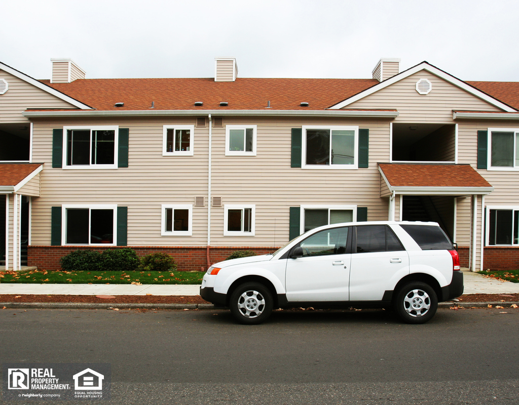 White Vehicle Parked on Street in Front of Apartment Complex