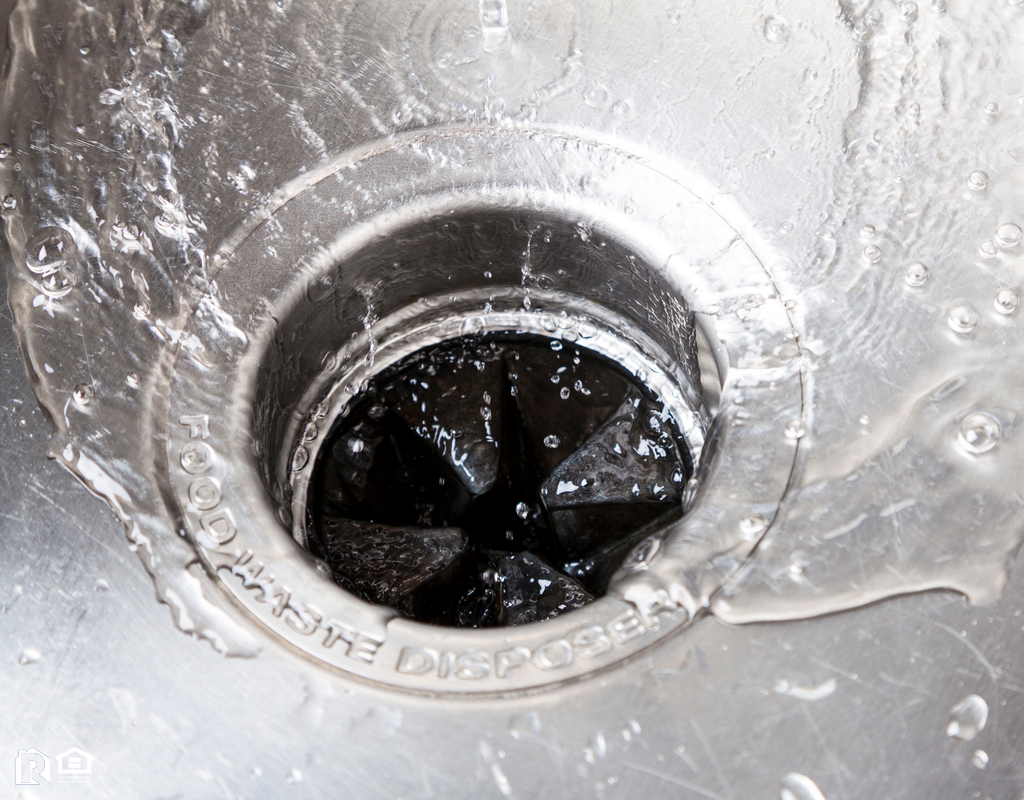 Sink with Water Flowing Down into a Garbage Disposal