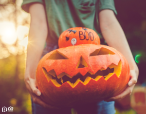 Boonville Resident Holding a Stack of a Decorated Pumpkin and a Jack-o-Lantern