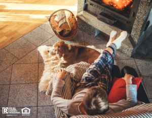 Child and Dog Sitting in Front of Fireplace in Cozy Living Room During Fall