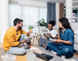 Three roommates gathered at a table in their cozy co-living space.