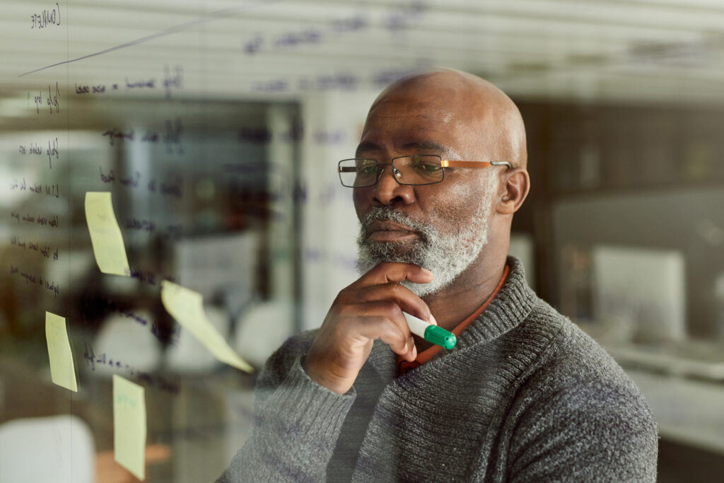 Cropped shot of a local investor brainstorming with notes on a glass wall.