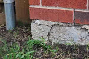 Picture of a crack on the corner of a residential building, crack indicates settlement and movement and a foundation problem. 