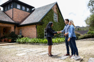 real estate agent meeting a couple in front of a home