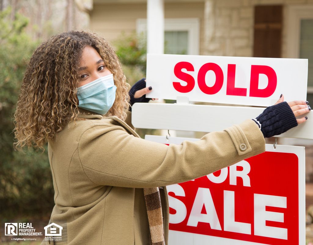 Real Estate Agent with Face Mask Holding Sold Sign