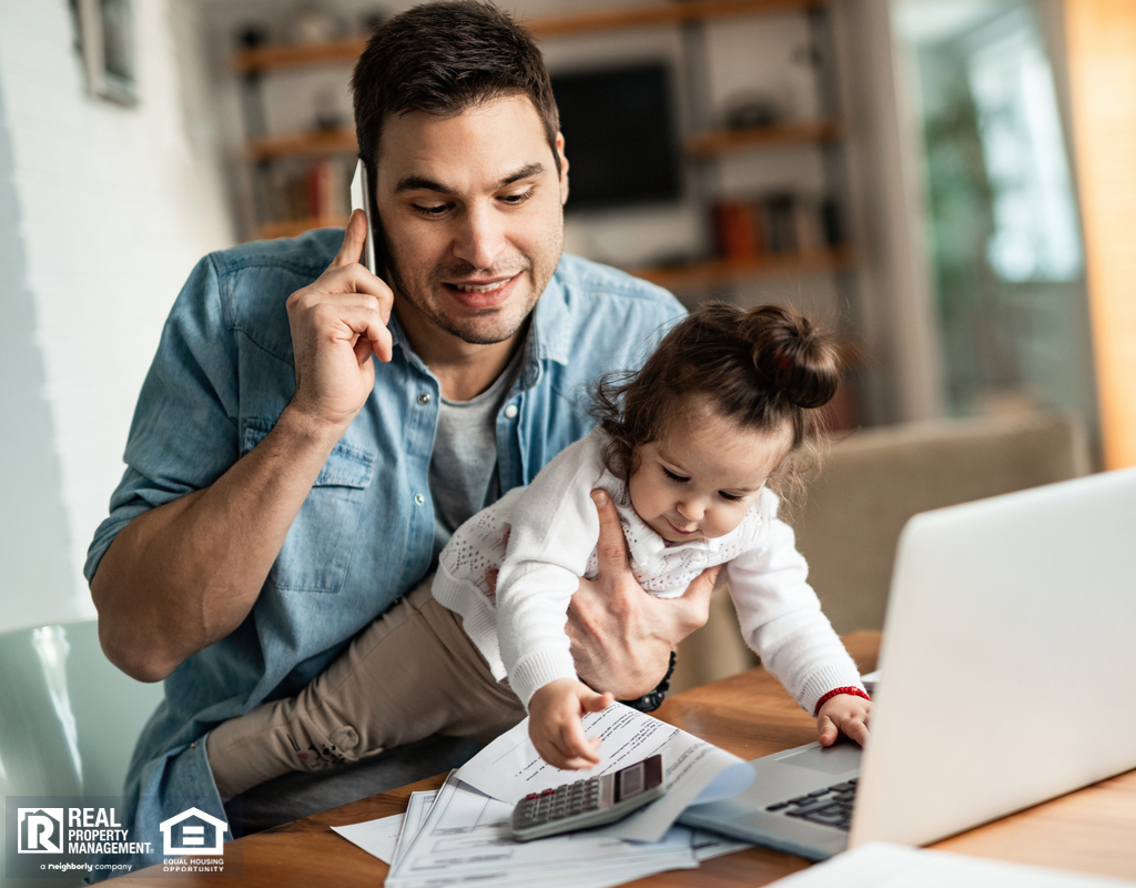 Remote Worker Holding His Baby While Working from Home