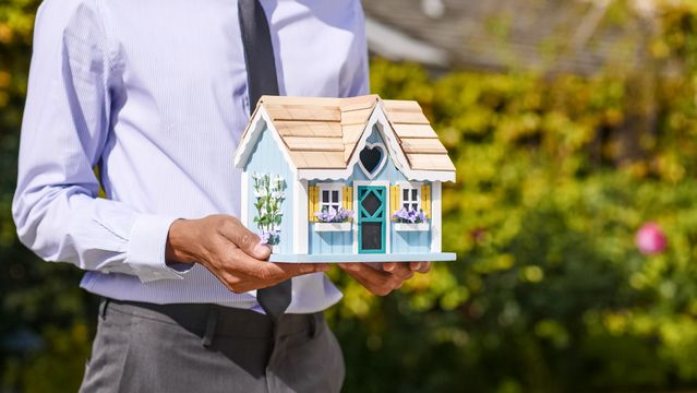 a person holding a decorated house model