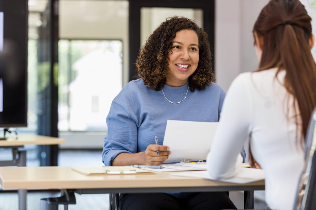 Property manager holds an application while speaking with a potential tenant.