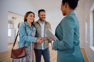 Happy woman shaking hands with property manager