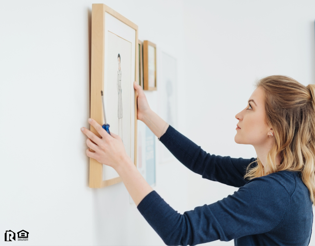 Leander Tenant Hanging Artwork in Their New Home