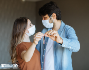 Couple with Face Masks Holding Keys to Their Leander Apartment