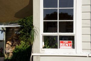 A white window frame showcasing a bright, inviting space available for rent.