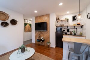 Small apartment with a neat kitchen and living room, including a TV, designed for efficient and cozy living.