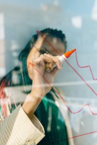 Woman writing on glass with red pen