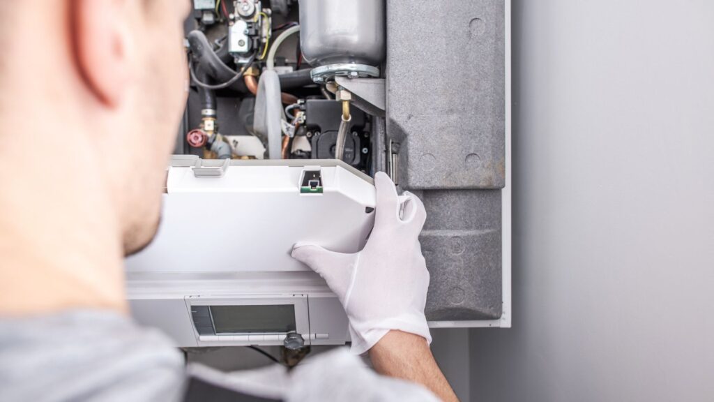 Technician inspecting and servicing a residential furnace system during routine maintenance.