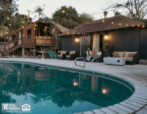 Two women enjoying a beautiful evening with a drink by the poolside of their rental house.