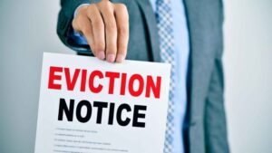 person in a business suit holding up a paper with the word eviction notice