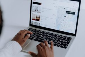 person looking at rental listings on a laptop
