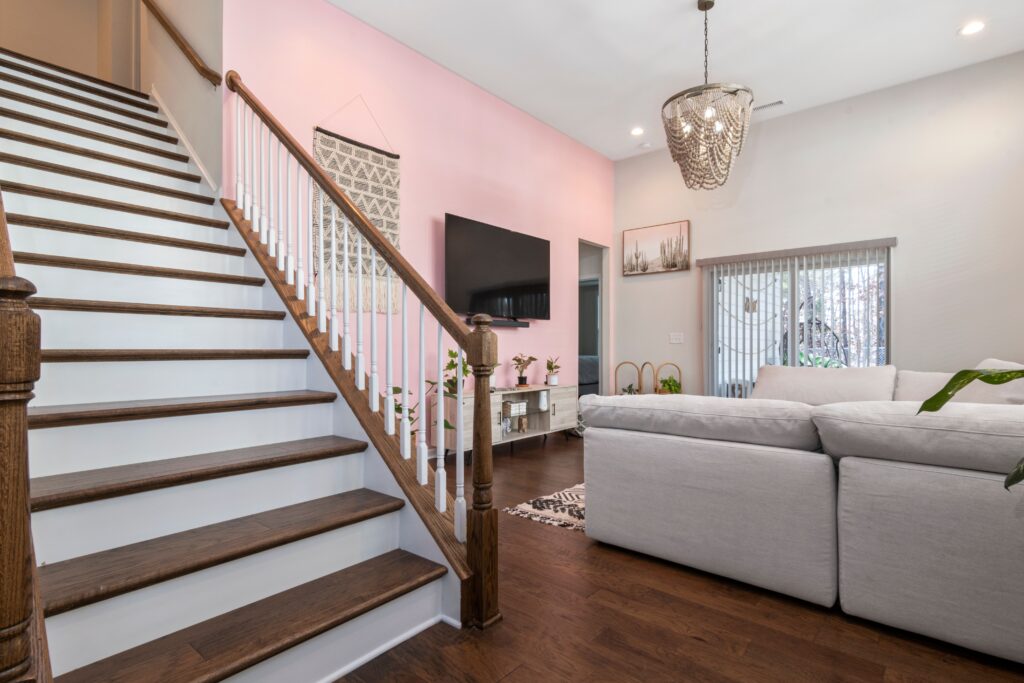 Cozy House Interior with Staircase on the left foreground and a living room in the background