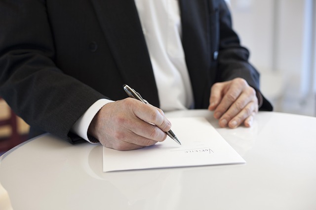 Person signing a contract at a round table