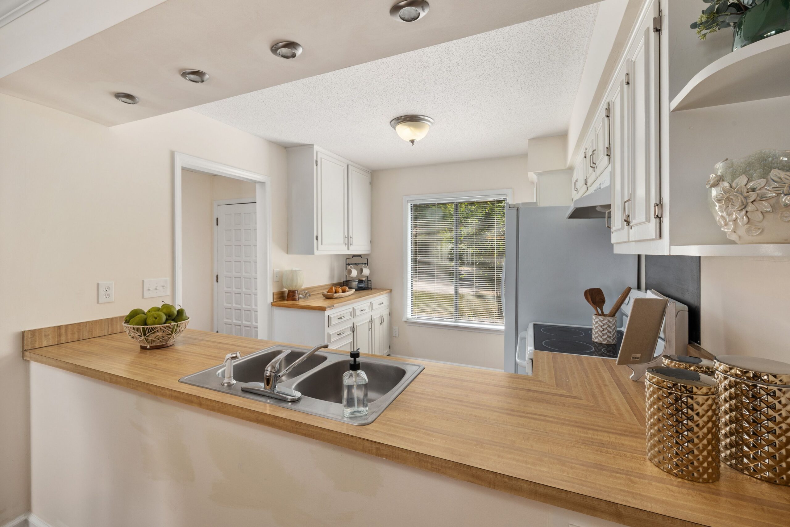 Bright kitchen interior featuring wooden countertops and white cabinets, perfect for home designs