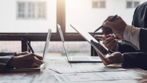 group of business people planning a project together with laptops in front of them