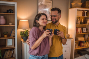 A carefree loving couple enjoys coffee in the living room of a modernly furnished apartment