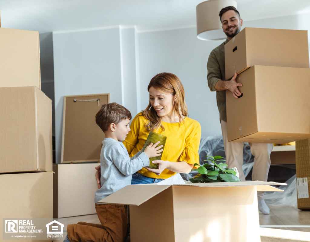 A family joyfully moving into their new home, surrounded by boxes and packing materials.