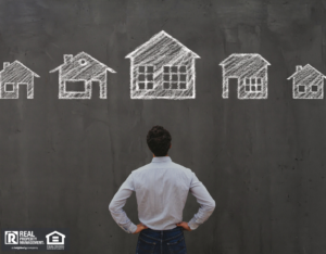 Man Looking at a Blackboard with Drawings of Houses