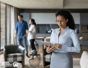 Property manager showing a house to a couple and using a tablet computer.
