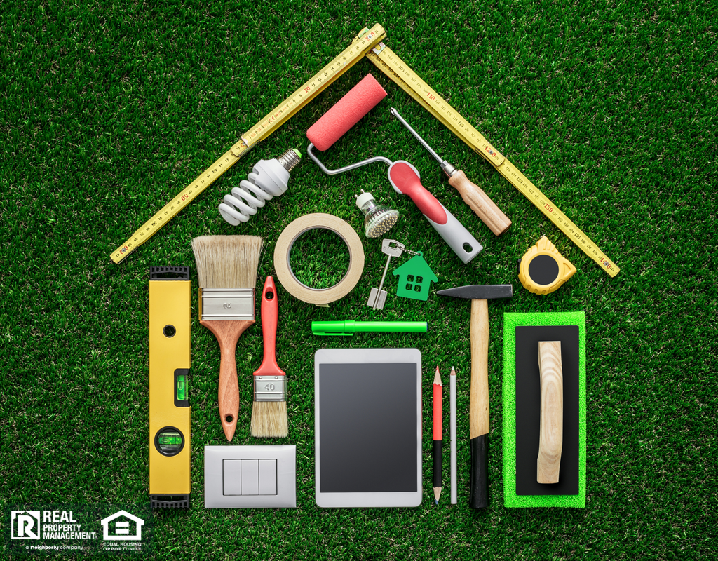 Home renovation, remodeling and DIY concept, work tools and tablet composing a house shape on the grass