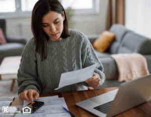 Woman checking monthly expenses and utility bills at home.