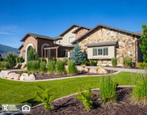 View of property and landscape with green grass and house.