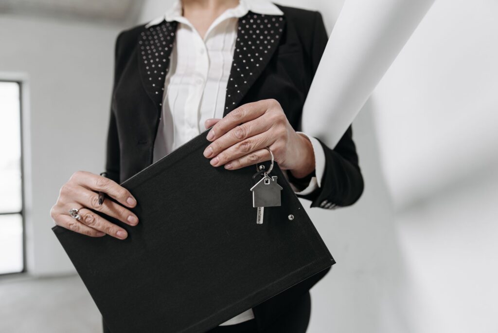 a person holding a folder and house keys