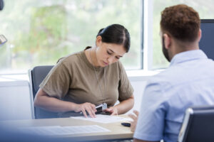 Adult female veteran signs paperwork with agent present