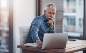 Liberty Property Manager Looking Thoughtfully at His Laptop