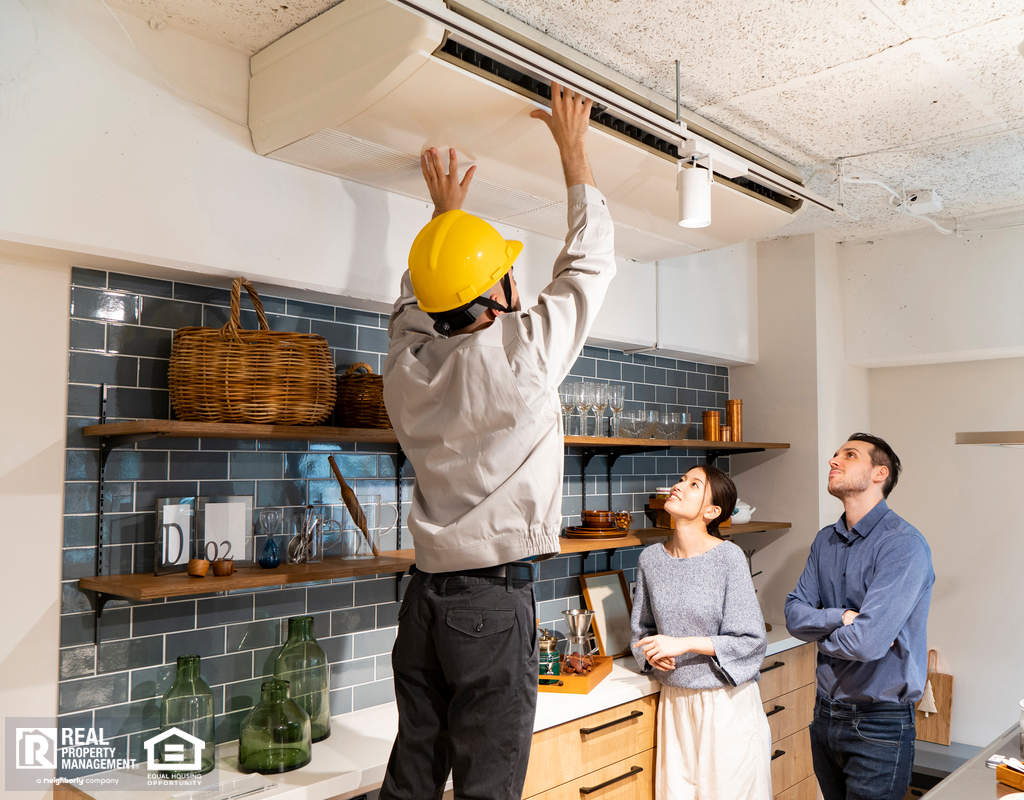 HVAC Repairman Servicing AC Unit in Kitchen
