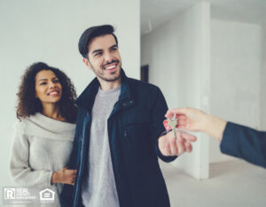 A couple smiles as they proudly display keys to their new rental house.