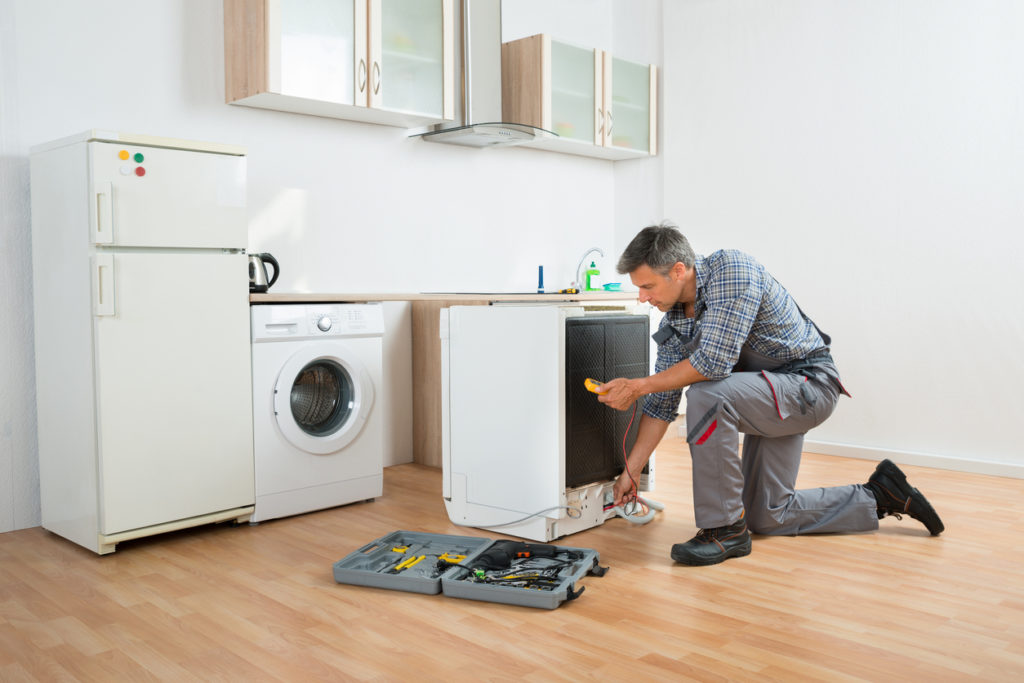 A man performing maintenance on home appliances