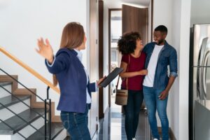 A property manager shows a happy couple their home.