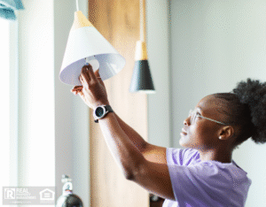 Young adult woman changing burnt out light bulb.