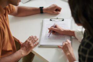 An agent and a property seller sitting down at a table looking at documents