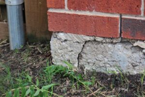 Picture of a crack on the corner of a residential building, crack indicates settlement and movement and a foundation problem.