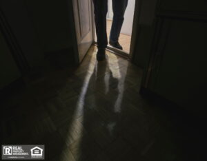 Suspicious person entering room with lights turned off.