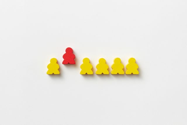 red figurine amongst yellow figurines