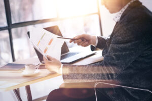 Real estate investor sitting at a desk with a laptop and a cup of coffee.
