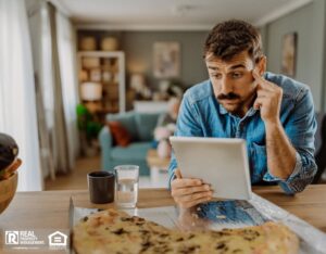 A confused man staring at his tablet.