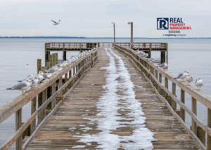 Winter scene at Colonial Beach pier with snow and seagulls along the railings, showcasing the Virginia Northern Neck waterfront during the holiday season.