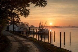 Sunrise over a quiet waterfront marina in Virginia’s Middle Peninsula with fishing boats and calm water reflecting the morning light.