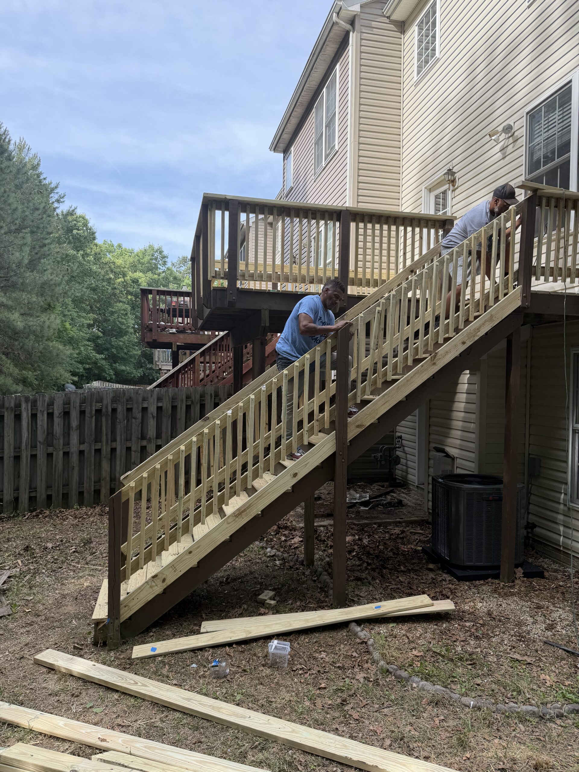 Maintenance professionals rebuilding an exterior staircase at a residential rental property in Virginia.